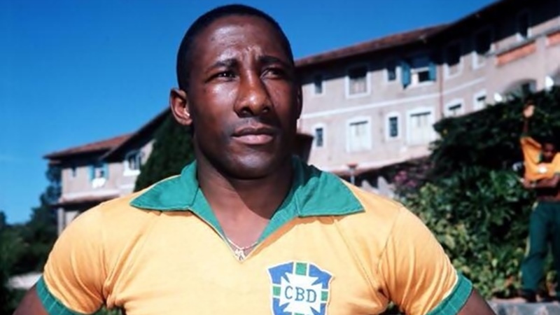 A imagem mostra Djalma Santos com as mãos na cintura olhando para frente e com a camisa da Seleção Brasileira